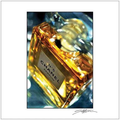 A close-up of a Chanel perfume bottle with a gold label and amber liquid.