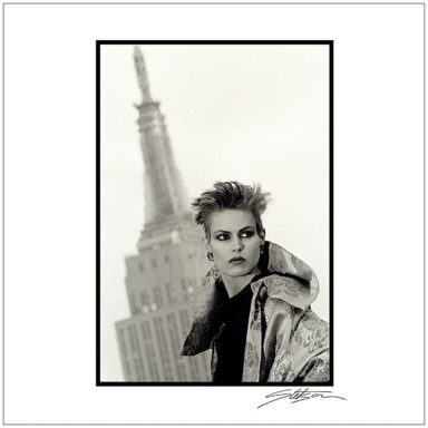 Woman with short hair wearing a metallic jacket, with the Empire State Building in the background.